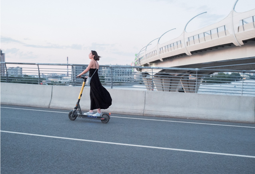 mujer conduciendo patinete electrico barato